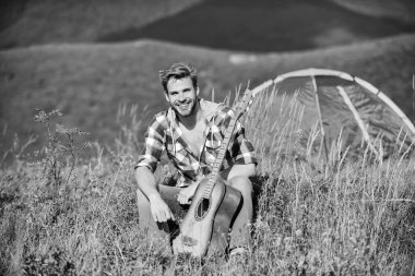 İlham arayan bir müzisyen. Yaz tatili doğada var. Hayalperest gezgin. Tek başına iyi vakit geçirdin. Huzurlu bir ruh hali. Gitarlı adam doğayı düşünüyor. Seyahat tutkusu konsepti. İlham verici doğa.