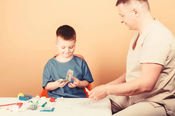 Infancia. crianza. médico de familia. niño feliz con padre con estetoscopio. medicina y salud. padre e hijo en uniforme médico. Un niño pequeño con papá en el hospital. Feliz. felicidad infantil —  Fotos de Stock