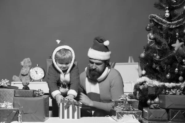 Boks günü. Çocuk ve Noel Baba güzel paketlenmiş kutuların arasında otururlar. — Stok fotoğraf