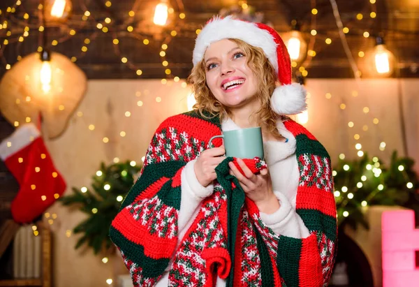おはようございます。陽気な女性は居心地の良い...お祝いの時間を感じる。クリスマス気分だ。女性はココアを飲む。サンタ・ハットのミルクカップ。冬休みだ。モーニングコーヒー。新年明けましておめでとう。クリスマス — ストック写真