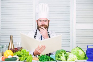 Nihai aşçılık rehberi adım adım. Kitap tarifleri boşluğu kopyalıyor. Şapkalı ve önlüklü adam kitap okudu. Yemek tarifleri kitabı konsepti. Yemek pişirme yeteneğini geliştir. Yemek pişirmek için faydalı bir kitap. Aşçılık kariyerine başla