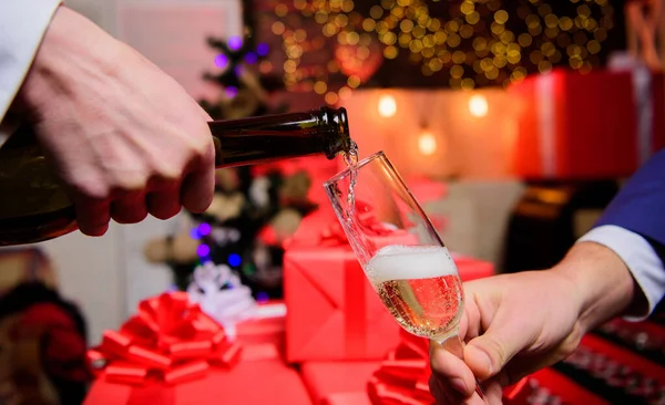 Celebre o Ano Novo com o champanhe. Mãos derramando champanhe em vidro elegante fundo decorações de Natal. Um conceito de saúde. Último minuto antes do ano novo. Beba champanhe ou espumante — Fotografia de Stock