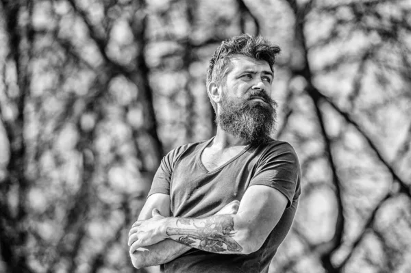 Man attractive bearded hipster posing outdoors. Confident posture of handsome man. Guy masculine appearance with long beard. Barber concept. Beard grooming. Beard care. Masculinity and manliness