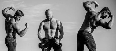 Üç kaslı vücut geliştirici. Sporcu adamlar dışarıda antrenman yapıyor. Spor koçu halter ya da halter kullanır. Spor aletleri. Sağlıklı ve enerjik kalın. Vücut geliştirme spor disiplini. zinde ve güçlü