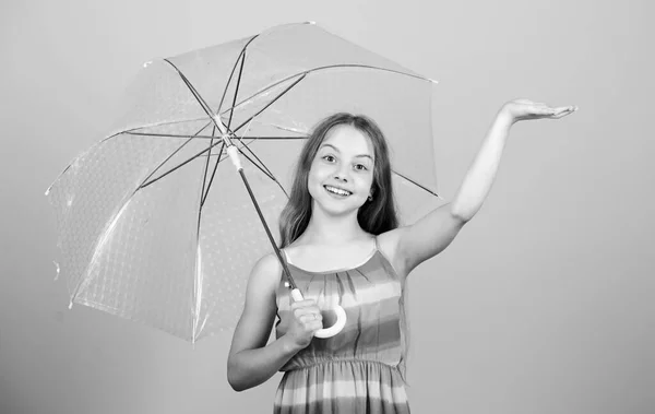雨天来了喜欢雨天。小女孩高兴地拿着透明的伞.多雨的天气。无形的保护。季节性的变化。秋天的季节享受雨的概念。防水配件 — 图库照片