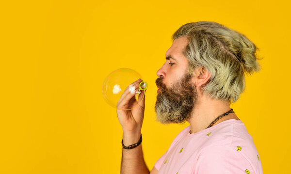 april fools day. bearded man blowing soap bubbles. carefree man with bubble blower. happy hipster in playful mood. Fall into childhood. feeling childish and childlike. real happiness. copy space