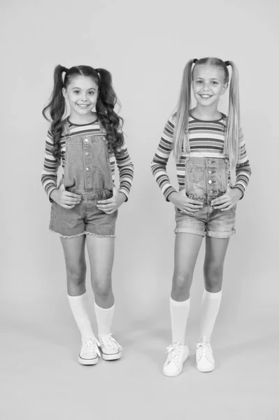 Μοντέρνο και φανταχτερό. Κοριτσάκια που φοράνε ρούχα ουράνιο τόξο. Ταιριαστά ρούχα. Κατάστημα μόδας. Πρέπει να έχει αξεσουάρ. Ζωηρά χρώματα. Μοντέρνα μόδα. Παιδική μόδα. Τα κορίτσια μακριά μαλλιά. Χαριτωμένα παιδιά ίδια ρούχα — Φωτογραφία Αρχείου