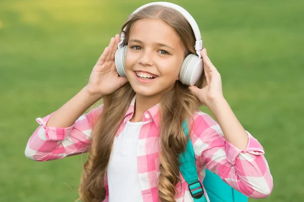 Concepto de audio libro. Estudiando lecciones de audio. Escucha música mientras caminas. Auriculares para chicas escuchando música. Podcast educativo. A la niña le gusta la música. Es un buen momento. Auriculares infantiles escuchar música — Foto de Stock