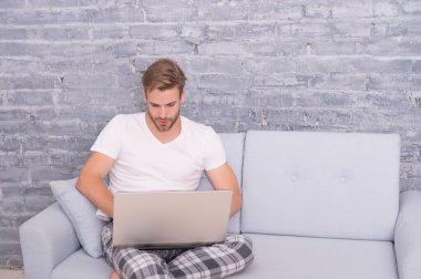 Online kurslar evde eğitim. İpuçlarını kilitle. Bir şeyler alıp internetten alışveriş yapmak. Adam kanepede bilgisayar kullanıyor. İletişim ve insan konsepti. Çevik iş. Sabah titreşimleri. Adam dizüstü bilgisayarda çalışıyor