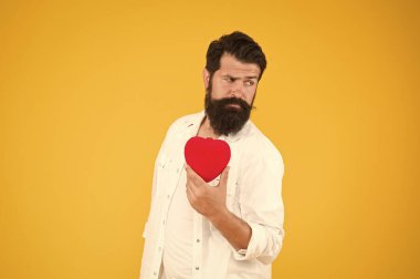 Sağlık hizmeti konsepti. Kontrol, kalp hastalığının risk faktörlerini anlamamıza yardımcı olur. Daha fazla fiziksel aktivite yapmak sigarayı bırakmak alkolü azaltmak. Sağlıklı bir kalp. Sakallı hippi adam kırmızı kalbi tutar.