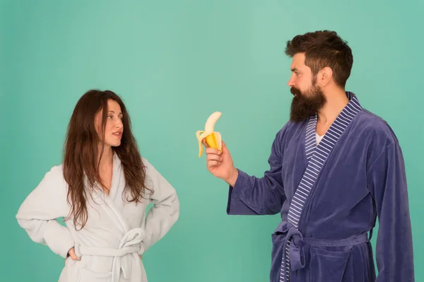 Healthy breakfast. Couple sleepy faces domestic clothes eat banana. Couple in love bathrobes. Advice relationships surviving quarantine. Morning routine. Sharing food. Healthy food. Food for health