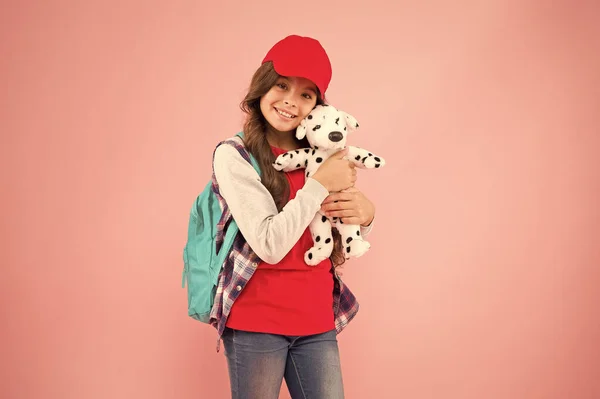 Schoolgirl daily life. Schoolgirl street style clothes. School club. Stylish schoolgirl. Girl little fashionable cutie with backpack carry soft toy dog. Take favorite toy with you. Reduce stress