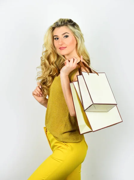 Sexy blondine draagtassen. elegante vrouw shopaholic. Meisjesshopper houdt paperbag pakje vast. Koop cadeautjes online. Cadeauwinkel voor elke vakantie. Uitverkocht op zwarte vrijdag. mooie aankoop — Stockfoto