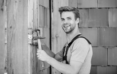 Çekiç aletli bir mühendis. Çekiç tuğlalı arka planı olan bir işçi. Bina ve inşaat. Genel bakım ve onarım işçileri bakım ve onarım işleri için işe alınır. Çekiç kullan