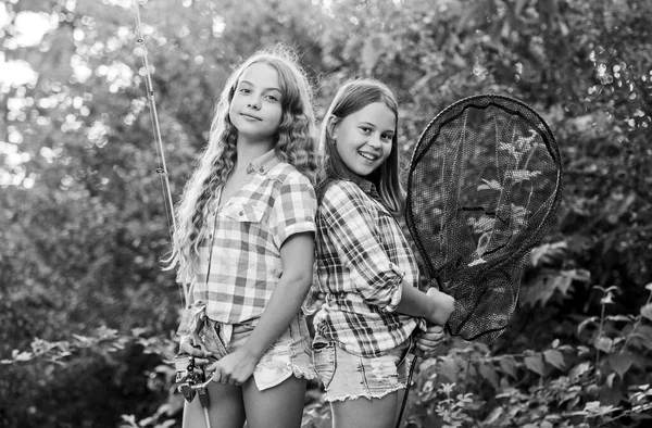 Gone Fishing. two girls fishing. Big game fishing. summer hobby. happy children with net and rod. summer holidays weekend. Fly Fishing Time. little kids spend time in camp. having fun. fish angler