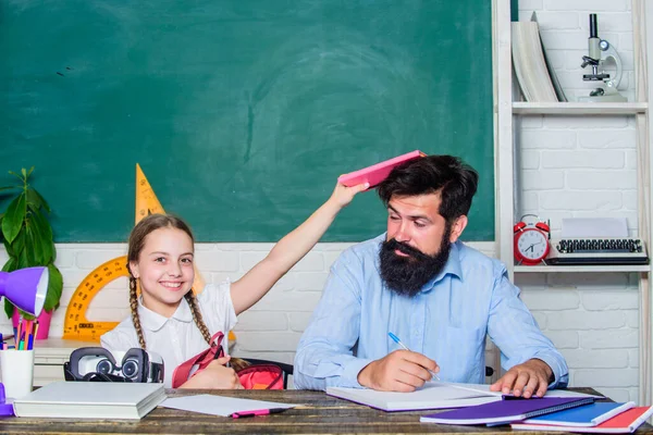 Man skäggig pedagog studie tillsammans med barn. Principen om belöning och straff. Hjälp till att studera. Disciplinär och uppfostran. Det är kul att studera. Lärare och skolflicka. Hemundervisning med far — Stockfoto