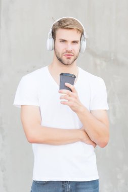 Müzik titreşimleriyle. Modern adam müzik dinleyerek kahve içer. Gençler için modern teknoloji. Paket servis içkisi. Modern müzik. Modern hayat. Aktif yaşam tarzı. Sıradan tarz ve moda.