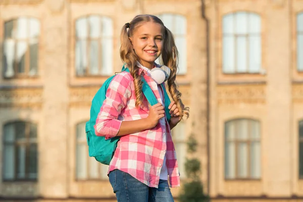 spring holiday just begun. her favorite summer playlist. child listen to music. smiling kid listening audio book. happy school girl wear earphones. little girl casual style with backpack