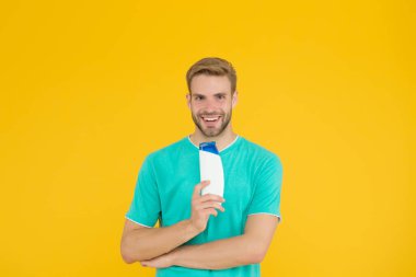 Yakışıklı adam şampuan şişesini tut. Saç bakımı. Sağlık ve sağlık hizmetleri. Erkek kozmetikleri. Profesyonel berber. Banyo ya da duş için vücut bakım ürünleri. Sakallı adam jel tüpü tut. Berber Dükkanı Bakımı