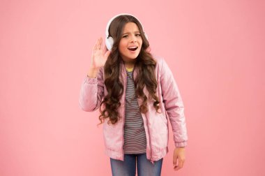 Duymama izin ver. Müzik neşe verir. Mutlu çocuk pembe arka plan müziği dinle. Küçük kız müzik çalarken kulaklık takıyor. Çocuklar için yeni teknoloji. Eğlence ve eğlence. Modern yaşam tarzı
