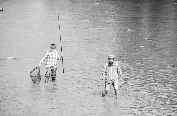 Ensina o homem a pescar e alimenta-lo para sempre. Amizade masculina. Pescando pai e filho. Fim de semana. Pescador feliz com vara de pesca e rede. Atividades hoteleiras e desportivas. Pesca em conjunto — Fotografia de Stock