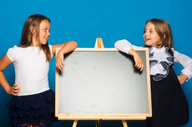 Mavi arka planda okul üniformalı kızlar