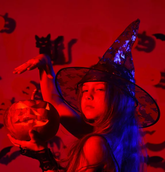 Kind in griezelige heksen kostuum houdt jack o lantaarn. — Stockfoto