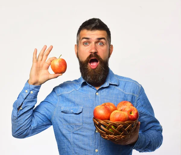 Фермер с удивленным лицом держит красное яблоко . — стоковое фото