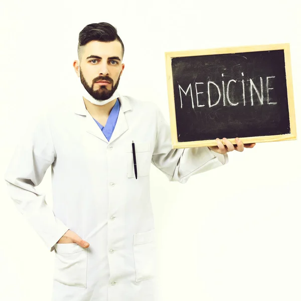 Doctor con barba sostiene poco pizarra con la palabra medicina —  Fotos de Stock