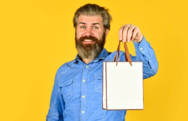 Giyim mağazası. Siber pazartesi ya da kara cuma. Satın aldığınız için teşekkürler. Alışverişten sonra sakallı mutlu bir adam. En iyi satış ve indirim burada. Tatil için hediyeler. Yetişkin hippi alışveriş çantası taşıyor.