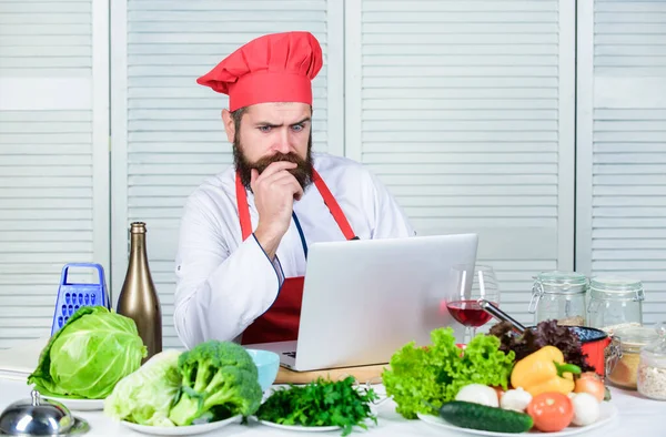 Chef laptop read culinary recipes. Culinary school. Hipster in hat and apron learning how to cook online. Culinary education online. Elearning concept. Man chef searching internet recipe cooking food
