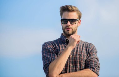 Ultraviyole koruma kavramı. Erkek gözlüklü model açık havada mavi gökyüzü arka planı. Mükemmel görüş. Net olarak gör. Yakışıklı adam güneş gözlüğü takıyor. Moda güneş gözlüklü hippi. Moda güneş gözlüğü.