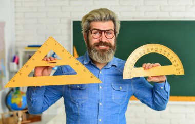 Kök eğitim konsepti. Üniversitede cebir okuyorum. Okula dönüyorum. Aritmetik öğretmeni. Çeşitli verilerin hesaplanması ve aranması. Hassas ölçüm aracı. İnsan açıölçer ve üçgen kullanır