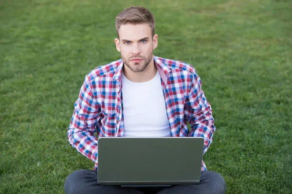 Laptop that is right to blog. Young blogger use laptop on green grass. Handsome man with laptop computer outdoors. Notebook and pc. Laptop technology. Modern life. Internet surfing. Start blogging
