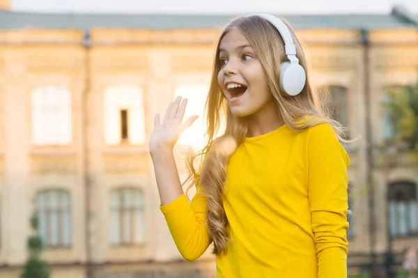 Give five. Happy kid open hand in greeting outdoors. Little child listen to music. Stereo sound technology. New technology. Modern life. Technology for having fun. Stay tuned with technology