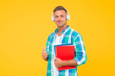 Keşfedilecek en iyi online öğrenme platformları. İnternette konferans dinleyen adam. Yetişkin öğrenci müzik dinler. Adam kulaklık takıyor. Sonsuz öğrenme. Karantina sırasında uzak öğrenim için çevrimiçi kurslar