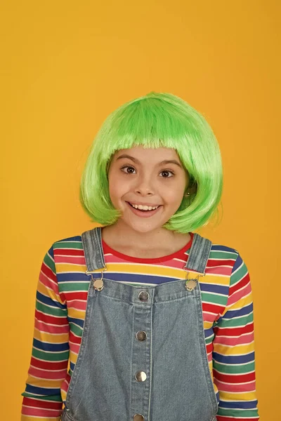 Varken kapsel dat is gemakkelijk te beheren. Gelukkig meisje dragen groene haar pruik gele achtergrond. Klein meisje glimlach met korte pruik kapsel. Mooie pruik of vals haar. Mode en schoonheid. Schoonheidssalon — Stockfoto