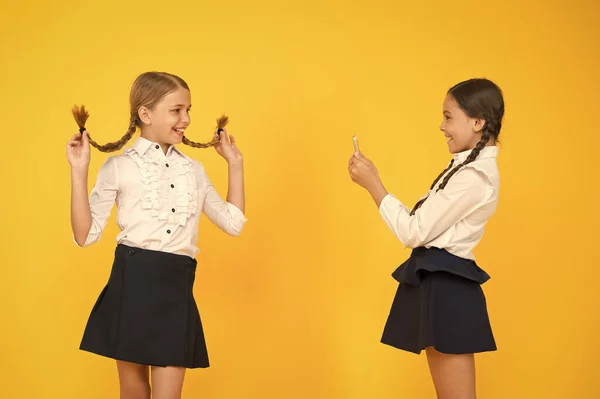 School girls use smartphone to take photo. Girls school uniform. Dont give anyone your password address or any information about your family. Life online. School application smartphone. Personal blog