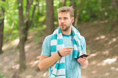 Fitness hedeflerinize teknolojiyle ulaşın. Formda adam akıllı telefonla antrenman yapıyor. Atletik adam forma girmek için teknolojiyi kullanıyor. Mobil teknoloji. Spor ve spor. Daha akıllı eğitim teknolojisi