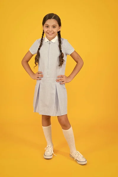 Retro-look. kind in vintage stijl. Old school. Kid mode. gelukkig kind op gele achtergrond. mode en schoonheid. jeugd geluk. grappig humeur. klein meisje in school uniform. moderne school — Stockfoto