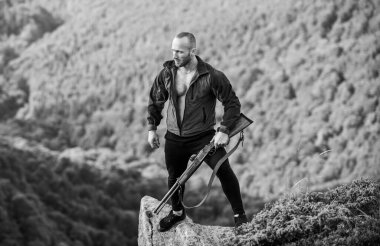 Kaçak avcı uçurumun kenarında duruyor. Kaçak avlanma kavramı. Adam vahşi kaçak avcı, silah ve doğal manzara. Avcı kaçak avcı kurban arıyor. Tüfek doğası olan bir avcı. Yasadışı avlanma