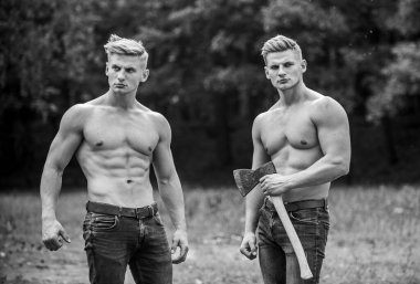 Atletik ikizler balta kullanır. Gövdesi kaslı adamlar. Genetik konsept. Kardeşlik dostluğu. Dayanıklılık ve azim. Güçlü erkek doğası. Baltalı, grup kaslı adamlar. Yakışıklı kardeşler.