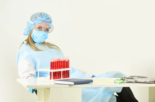 看護師は研究室で働いてる。治療のための感染症治療薬を探す。ウイルス検査を。血液検査を受けて。分析のために血液を寄付する。コロナウイルスのパンデミック発生。女性医師は実験室で試験管を持ち — ストック写真