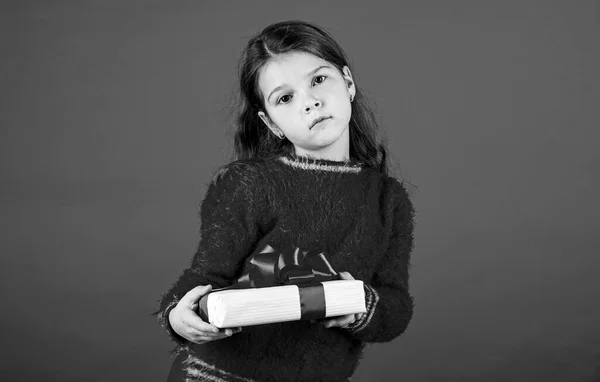 Día de boxeo. Una niña pequeña sostiene la caja de regalo. Niño mantenga la caja actual fondo rojo. Centro comercial. Chica del cumpleaños. Feliz Navidad y felices fiestas. Compras de regalos de Navidad. Paquete regalo. Sueños preciados — Foto de Stock