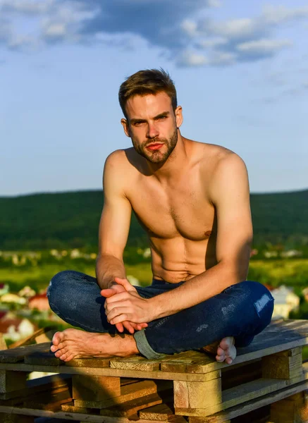 Relajante después del entrenamiento. hombre sexy desnudo en jeans. modelo de moda masculina en el fondo del cielo. verano relajarse al aire libre. deportista atlético tiene cuerpo sexy. un hombre musculoso al atardecer. macho hombre ha desnudo torso —  Fotos de Stock