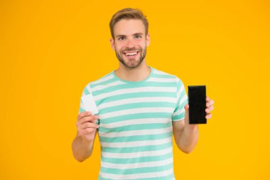 Daha ucuza satılıyor. Mutlu adamın elinde hediye kartı ve akıllı telefonu var. Satılık cep telefonu anlaşması. Özel fiyat. Satış fiyatı. Mağazada ve internette süper satış. Alışverişe git. Şimdi al ve indirim kartı al, boşluğu kopyala