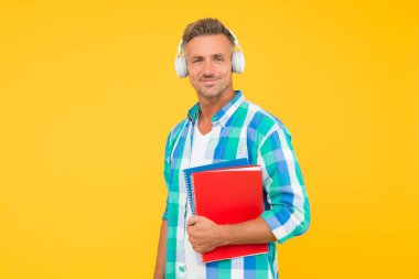 Ücretsiz yemek. Ses kursları. İngilizce öğreniyorum. Modern teknoloji. Ses kitabı konsepti. Dünya çapında bilgi erişimi. Ses kütüphanesi. Yakışıklı öğrenci kulaklık takıyor ve kitap tutuyor. Dil çalış