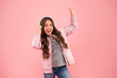 En sevdiği şarkı. Ses sesi. Akorda eşlik ediyorum. Mutlu çocuk müzik dinlemekten zevk alır. Küçük kız pembe kulaklık takıyor. Sesin tadını çıkar. Ses titreşimleri. Müzik ve teknoloji