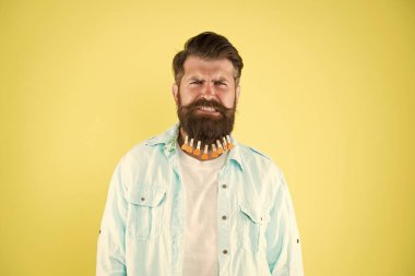 Çok canım yanıyor. Bireysel erkek saç stili. Adam sakallı mandal. Kalpli acımasız bir hippi. Sakallı adam sıradan sarı arka plan. Sevgililer Günü. Kuaförde saç kurutma