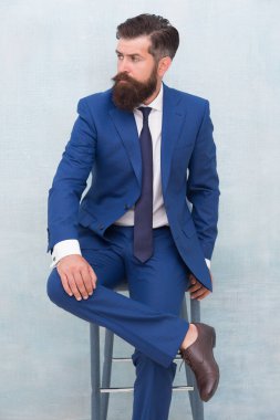 Şık ama modern. İş adamı sandalyeye oturur. Zarif iş adamı ya da girişimci. İş adamı resmi takım elbise giyer. Formalite icabı acımasız bir iş adamı. Resmi moda ve tarz. İş elbisesi kuralı